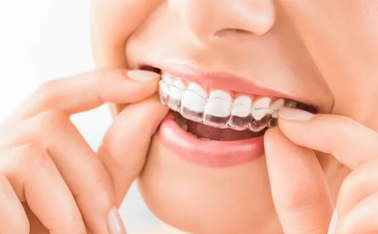 Clear aligner tray held up, nearly invisible orthodontic treatment