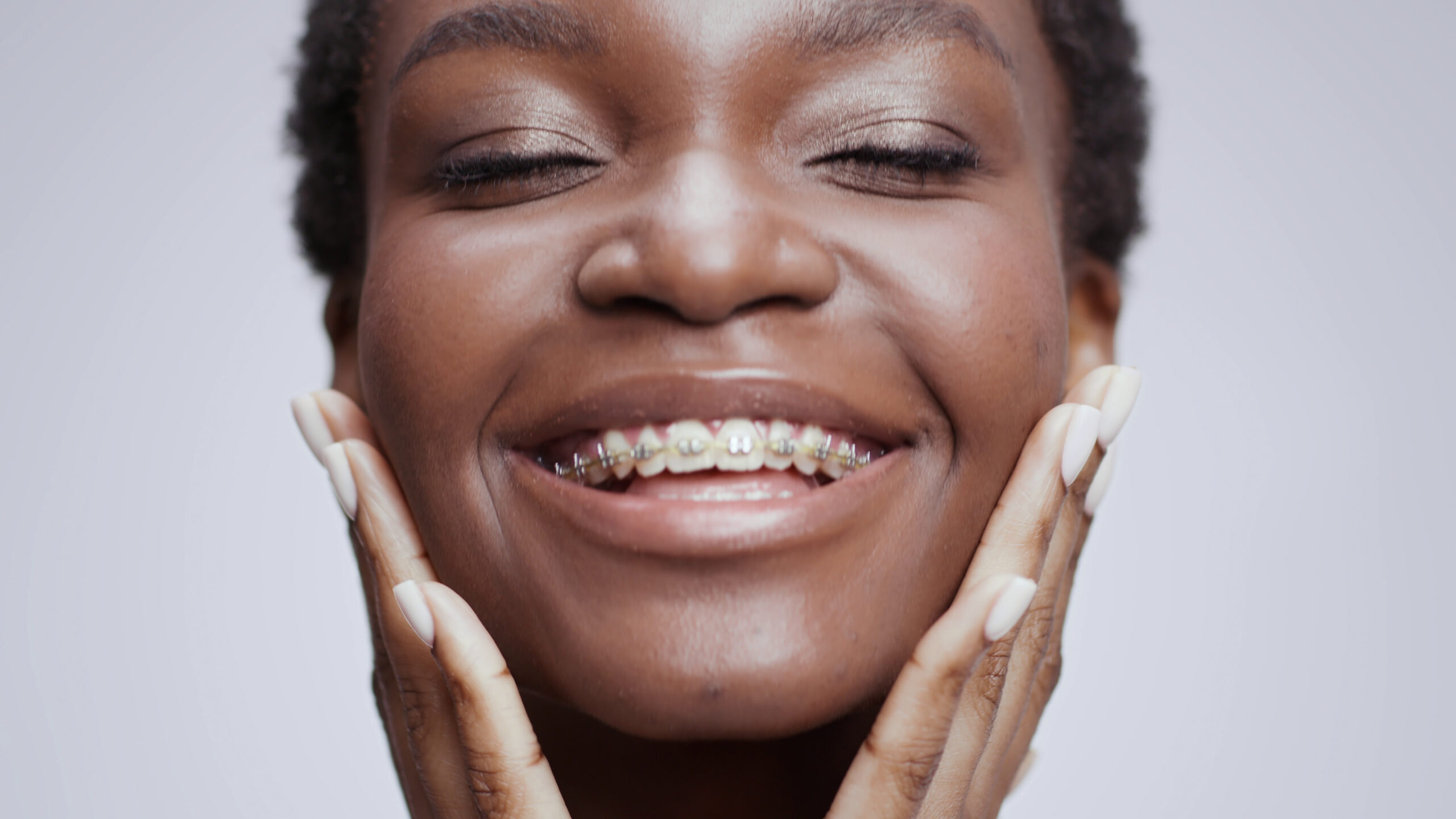 Self-confident adult woman smiling with dental braces